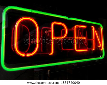 open neon sign in shop or store window at night