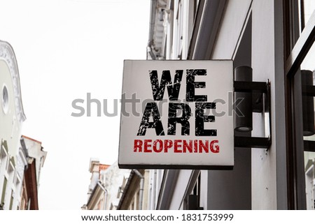 WE ARE REOPENING. Advertising sign on the wall of the house.