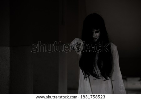 Horror woman ghost creepy hair close the face standing showing hand at dark house point finger to camera, Happy halloween day concept