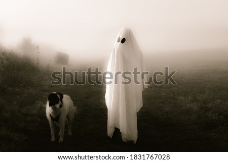 halloween ghost with dog in foggy landscape