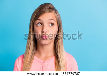 Photo portrait of pouting girl looking at blank space isolated on pastel blue colored background