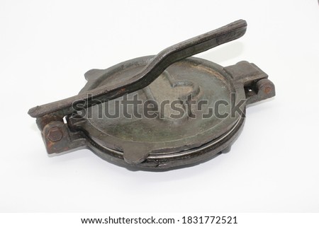 A picture of old and used roti maker on white background