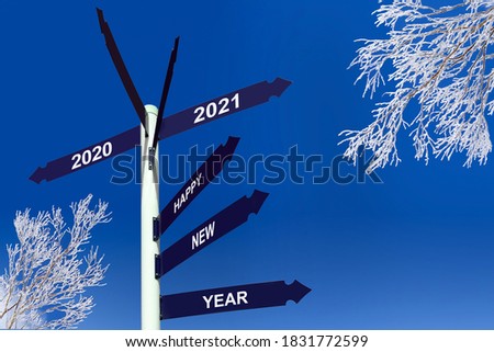 Happy new year 2021 on direction panels, snowy trees