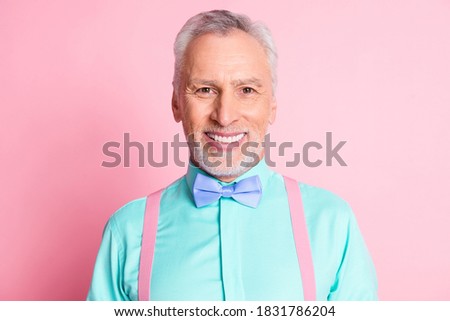 Photo portrait of happy smiling old man wearing nice shirt bowtie and suspenders isolated on pink color background