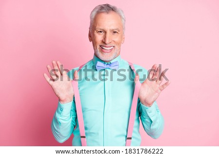 Photo portrait of smiling metrosexual with white beard keeping suspenders wearing shirt bowtie isolated on pink color background