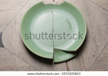 Broken green plate on gray background