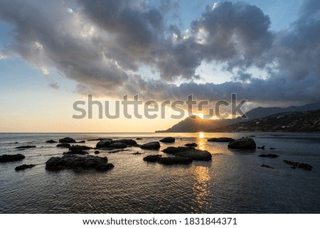 calm sea at sunset with rocks in the water