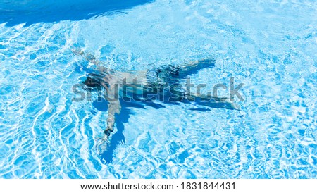 Man making star shape on the pool bottom. Guy like a star in pool. Person is sinking in pool. Drowning man Royalty-Free Stock Photo #1831844431