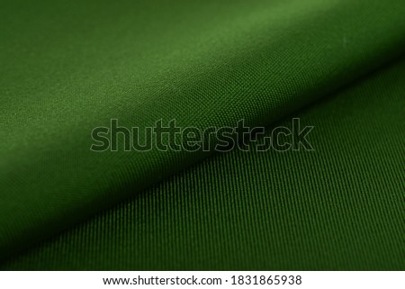 green Knitted elastic fabric, weaving of threads texture, crumpled fold. For underwear, sports clothes and swimwear. Space for text.