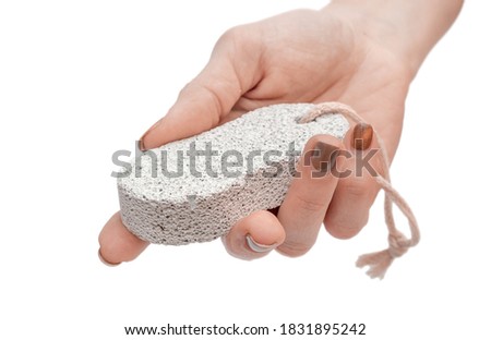 Hand holding pumice stone. Close up. Isolated on white.