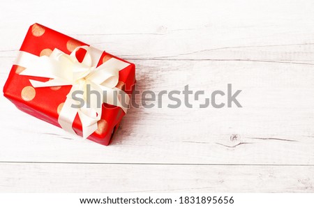 Merry Christmas and Happy New Year background. Christmas gift present with ribbon and bow isolated on wooden flat. Top view and copy space