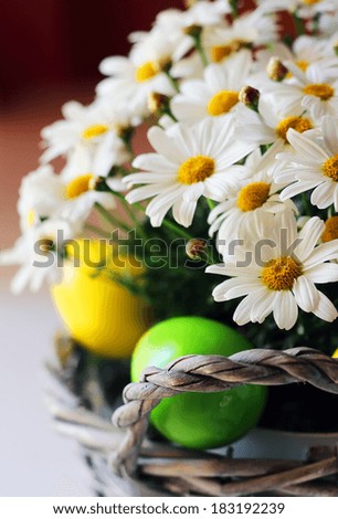 Photo of basket with daisy flowers and easter eggs