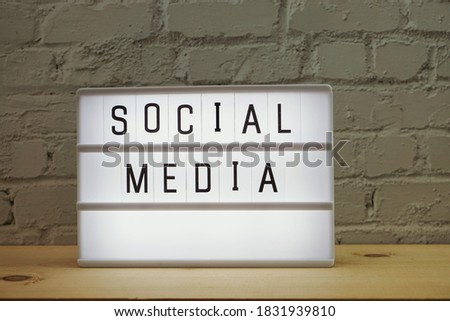 Social Media word in light box on wooden background