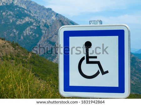 Disabled people parking sign against landscape background.