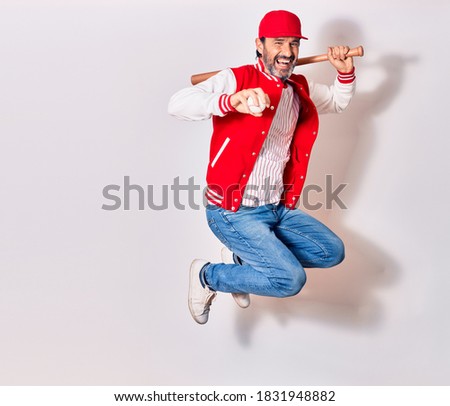 Middle age handsome man wearing sporty clothes smiling happy. Jumping with smile on face playing baseball using bat and ball over isolated white background