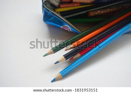 Colored pencils, pencil case on a white background. Drawing, art, children to school.