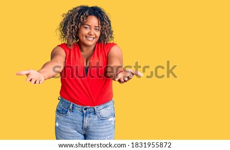Young african american plus size woman wearing casual style with sleeveless shirt smiling cheerful offering hands giving assistance and acceptance. 