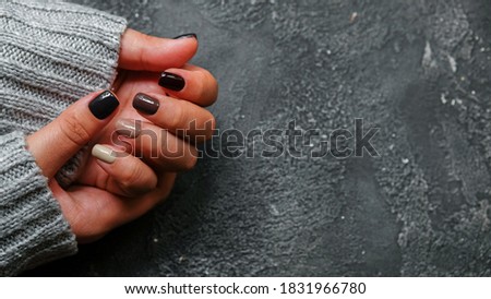 Women's hands with colorful pattern on the nails. 2020 colors trend. Top view. Place for text. Cozy autumn design.