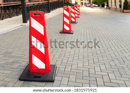 Red and white striped road warning posts on the road
