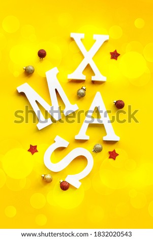 Christmas card with white XMAS letters on festive background. New year celebration. Holiday party decoration. top view