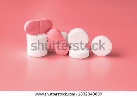 White and pink pills on a red background. Weight loss products, vitamins, hormones or sedatives. Women's health concept. Close-up, selective focus. Copy space Royalty-Free Stock Photo #1832040889