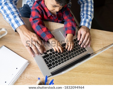 child with father using computer at home