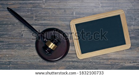 Judge or auction gavel beside a chalkboard on wooden background. Banner size with copy space.
