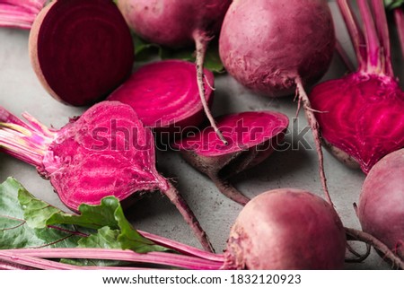 Cut and whole raw beets on light grey table