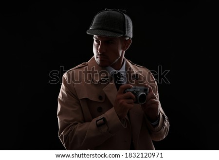 Old fashioned detective with camera on dark background