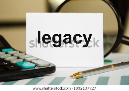 heritage - words written in a notebook near a calculator, money or property left to someone according to the concept of heritage, white background. High quality photo