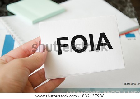  Focused on the business concept. blue sticker FOIA Freedom of Information Act. Business concept. Search idea. law. girl holding white sheet lettering. High quality photo