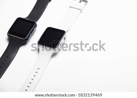 Electronic wrist watch on a white background . White and black wrist watches. Women's and men's watches. Isolated background. Article about modern watches. Article about choosing a watch. Royalty-Free Stock Photo #1832139469