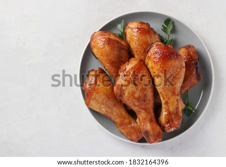 Roasted chicken drumsticks in honey and soy sauce on grey plate, top view. Space for text. Royalty-Free Stock Photo #1832164396