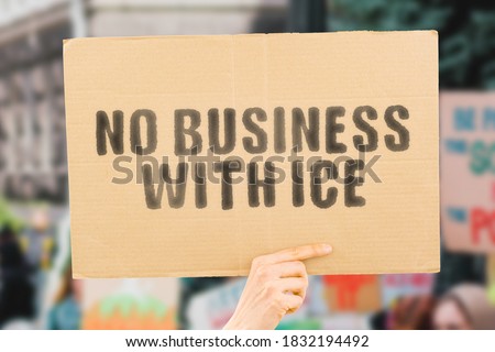 The phrase " No business with ice " on a banner in men's hand with blurred European Union flag on the background. Protest. Pollution. Climate change. Global warming. Destruction. Melting