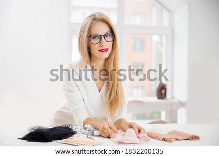 Fashionable business seamstress, portrait of happy woman tailor workplace sews.