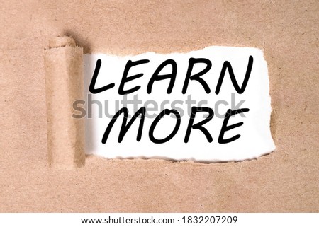 LEARN MORE, text on torn paper on a white backing