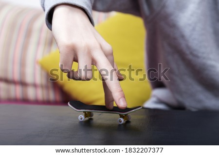 Boy is playing with his finger skateboard. Close up shot. Selective focus.