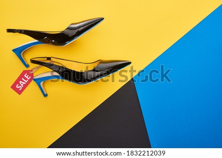 top view of shoes with sale label on blue, yellow and black background