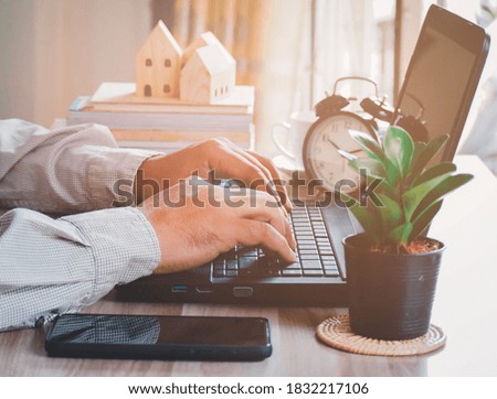 Businessman working on laptop while sitting at the wooden desk. work from home concept. 