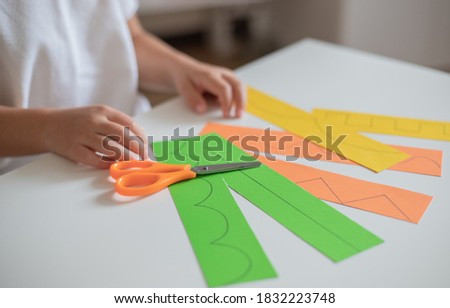Child teaching scissors skills , cutting lines, home education concept.