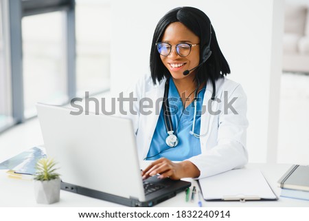 Portrait of african american happy smiling young doctor in headset consulting patient over the phone. Health care call center online concept Royalty-Free Stock Photo #1832240914