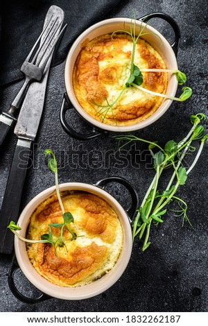 Cheese omelette , omelet with microgreens in a pan. Black background. Top view