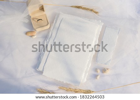 Blank paper card with copy space . Wedding ring and wheat on white textile background. Styled stock photography for display your design, lettering, font, illustration, wedding stationary. Flat lay