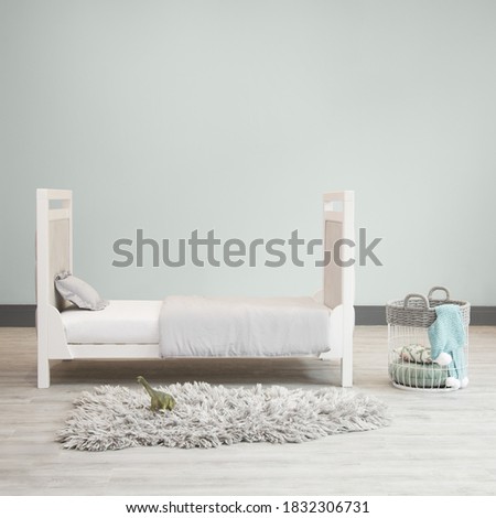 Blue and grey baby bedroom Nursery kids room. Cot and bed interiors with rainbow picture and faux fur rug.
Blue toy chests and blankets