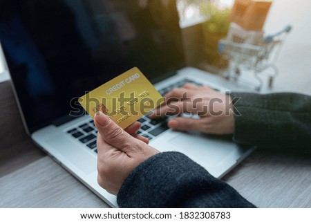 Close up Woman Hands holding credit card and using laptop for Online shopping,Toned picture,Online shopping, e-commerce, internet banking, spending money, working from home concept