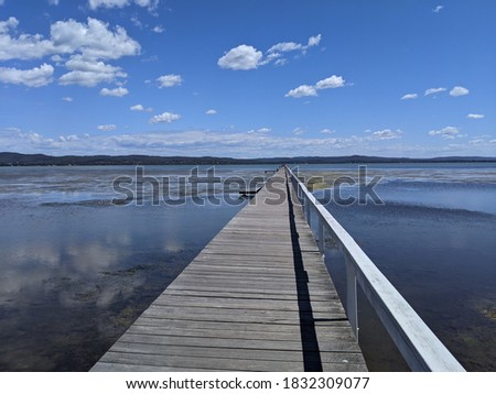photo of long jetti with  beautiful weather and clear blue sunny sky, reflex the view on the water, made the photo look piecefull and relaxing with full of natural view 