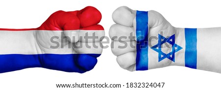 The concept of the struggle of peoples. Two hands are clenched into fists and are located opposite each other. Hands painted in the colors of the flags of the countries. France vs Israel