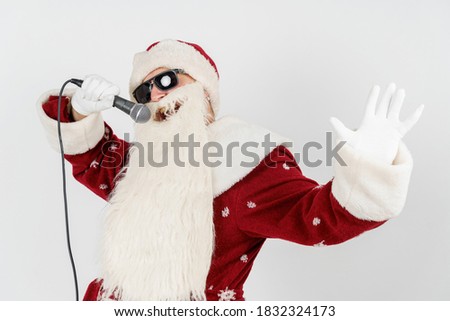 Holidays and christmas concept. Santa Claus sings with a microphone in his hand. Isolated on white