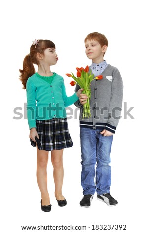 Girl and boy stand together and hold bouquet of flowers in hands. Girl is going to kiss. Isolated on white background