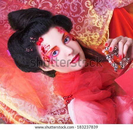 Young woman in creative image posing with present box.
